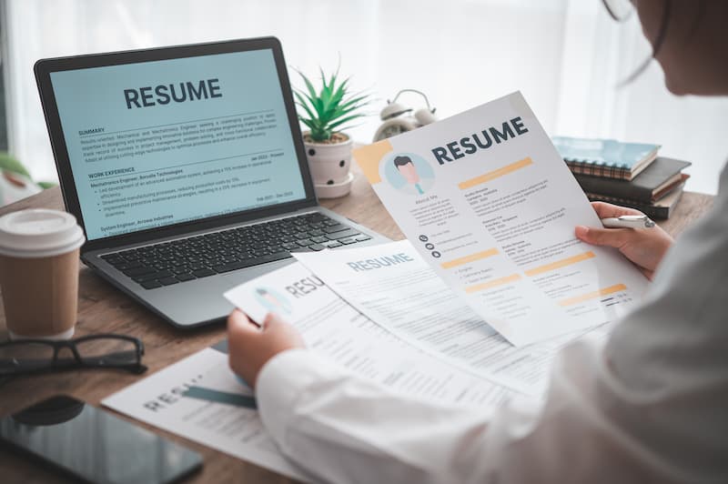A female recruiter looking at different resumes for a brand ambassador role.